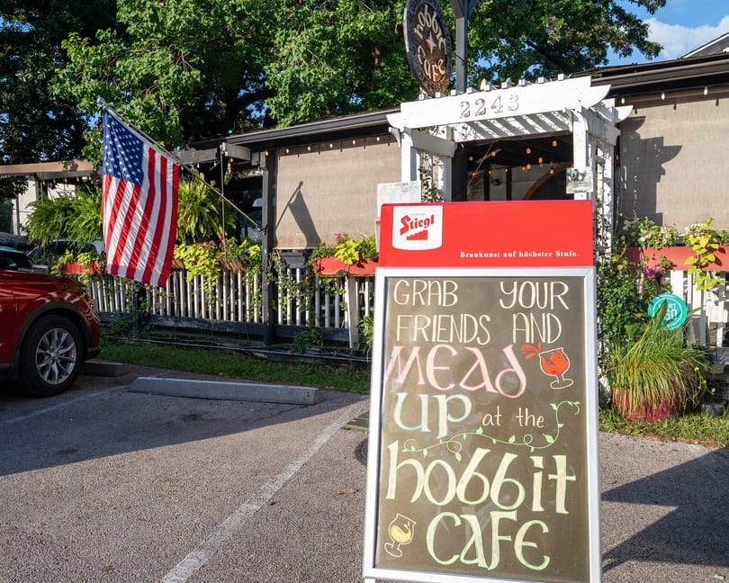 A chalkboard sign outside Hobbit Cafe invites guests to "Grab your friends and mead up."